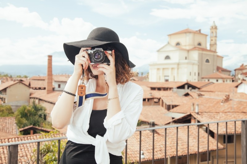 young-woman-wearing-straw-hat-photographing-old-town