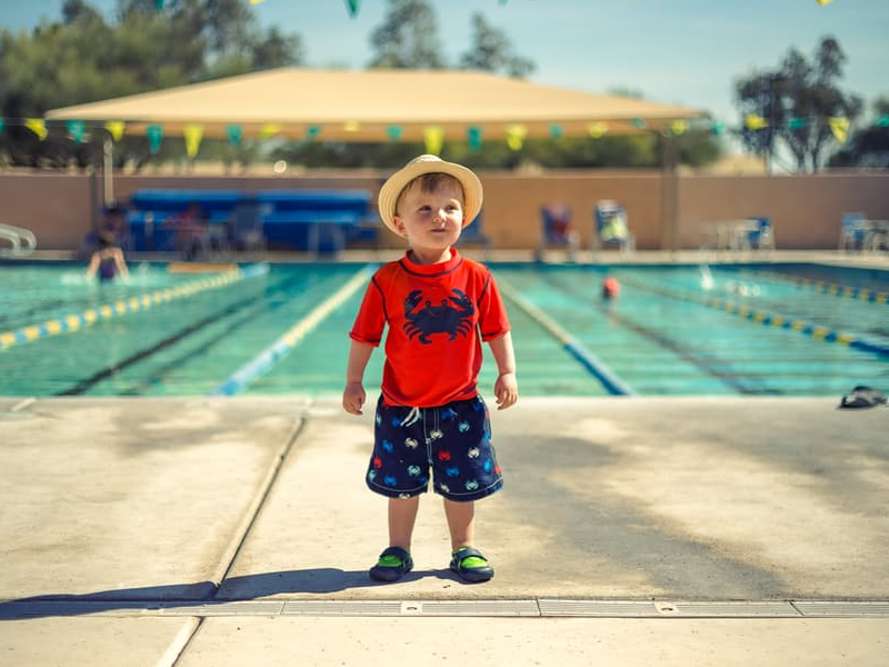 boy-standing-in-front-of-a-pool